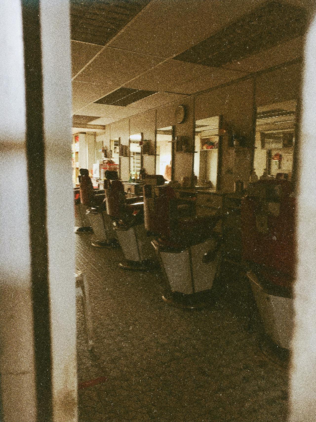 Stilvolles Barbershop-Interior mit Friseurst&uuml;hlen und warmem Ambiente